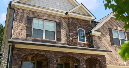 Brick Home Exterior Tilt Down Close Up. camera slowly lowers from the top of a modern residential new home build to the lower half of the home
