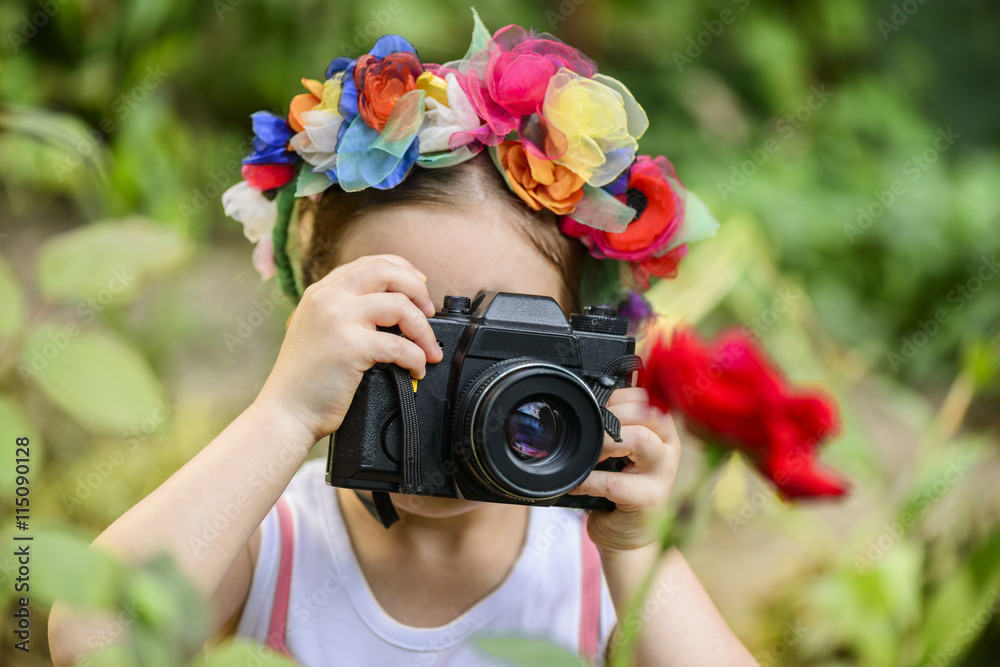 Φωτογραφία Young little girl wearing flower wreath with old vintage photo camera photograph