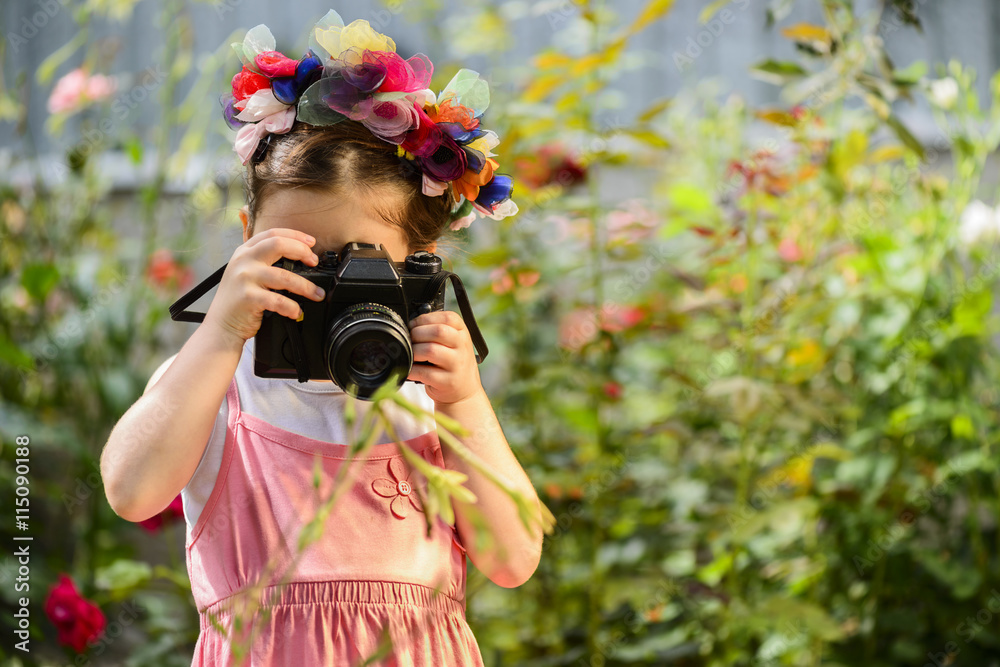 Φωτογραφία Young little girl wearing flower wreath with old vintage photo camera photograph