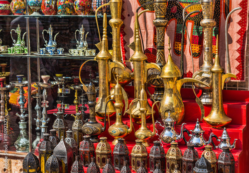row of shiny traditional coffee pots and lamp