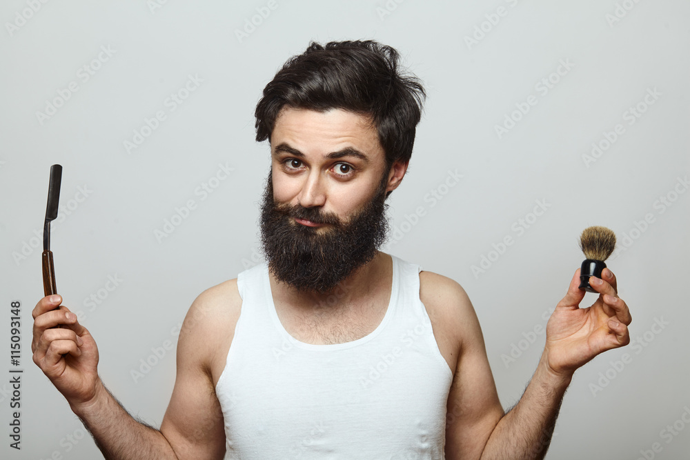 young funny man guy with beard showing razor blade young funny man guy with beard showing razor blade