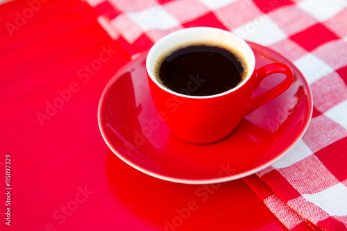 Cup of coffee at red wooden table