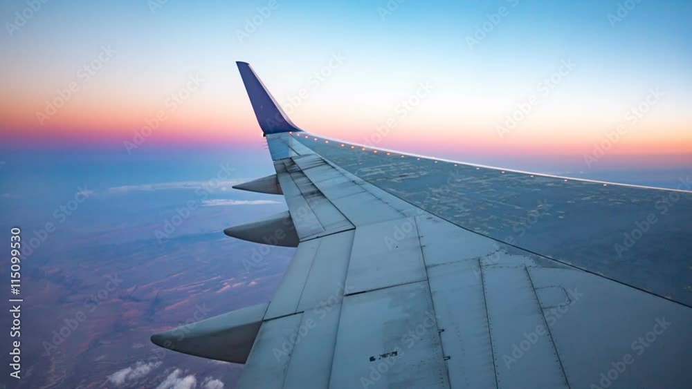 Plane Wing Aerial View During Sunset. view outside a plane window of the wing during sunset high above the surface
