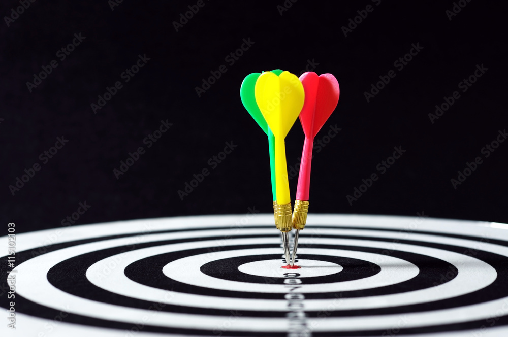Three darts on target. horizontal shot with black background. Three darts on target. horizontal shot with black background.