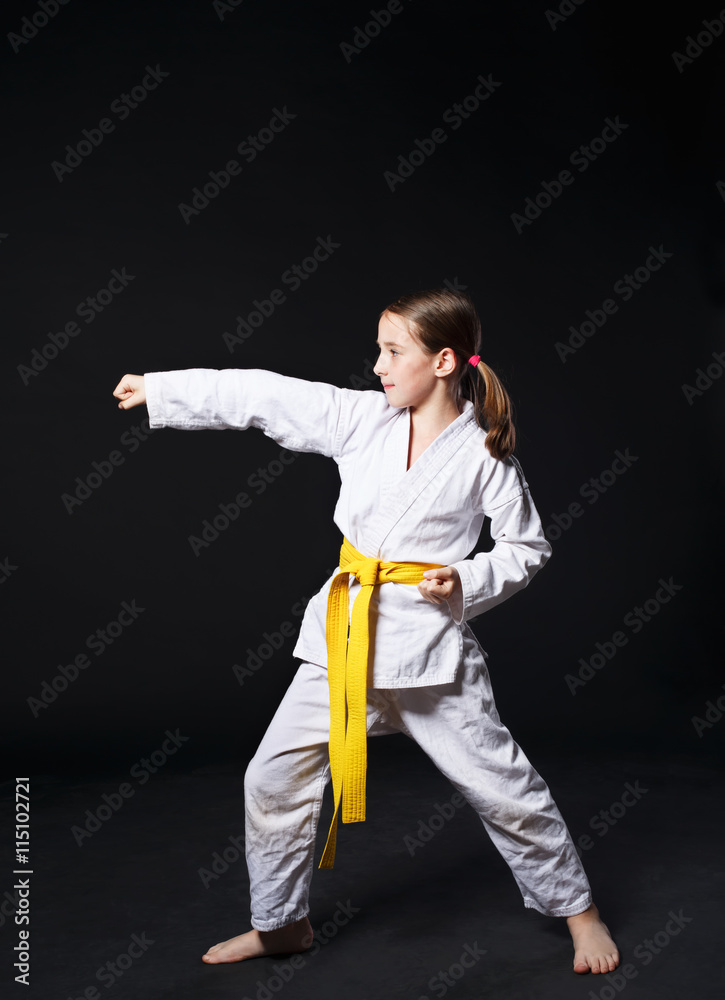 Child girl in karate suit with yellow belt show stance Child girl in karate suit with yellow belt show stance