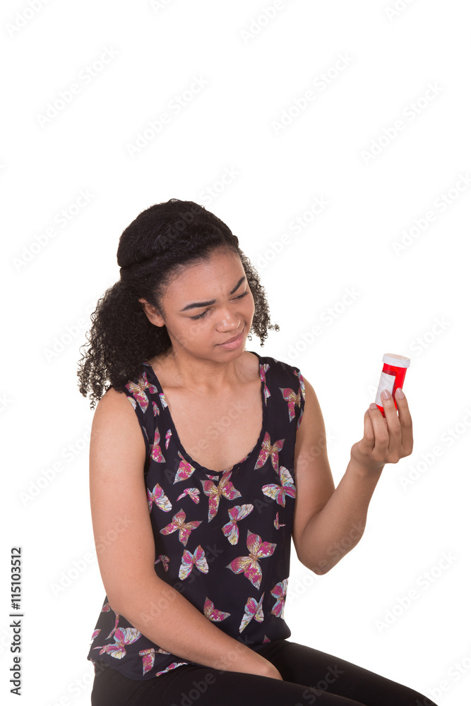 Young woman holding and reading the label on a pill bottle Young woman holding and reading the label on a pill bottle