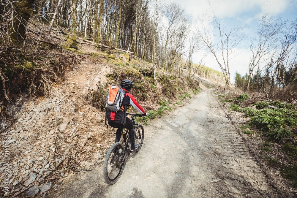 Mountain biker riding on dirt road on mountain Mountain biker riding on dirt road on mountain