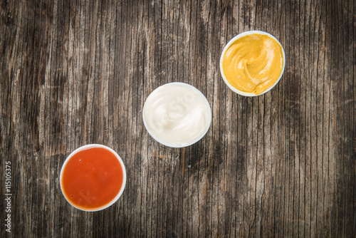 Obraz na płótnie Mustard, ketchup and mayonnaise on wooden table