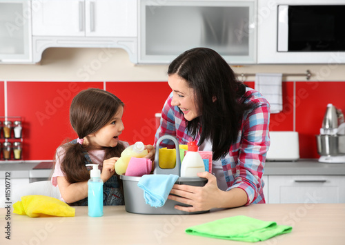 Daughter and mother in kitchen with cleaning set