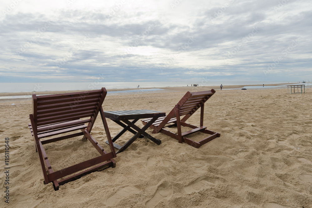 Cloudy sky on the beach and sea with relaxing table and chair