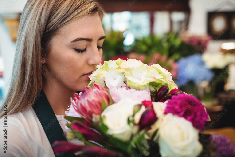 Female florist smelling flower bouquet Female florist smelling flower bouquet