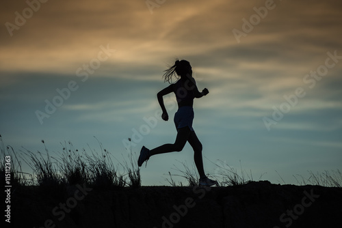 Fototapeta Naklejka Na Ścianę i Meble -  Runner athlete running on trail. woman fitness jogging workout wellness concept.