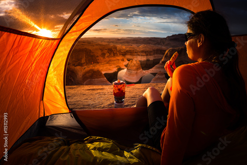 Camping Breakfast Young Woman enjoying a cookie looking at beaut