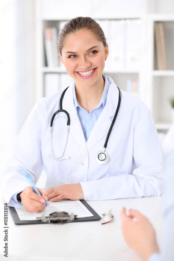 Friendly smiling doctor and patient sitting at the table. Very good news and high level medical service concept. Friendly smiling doctor and patient sitting at the table. Very good news and high level medical service concept.