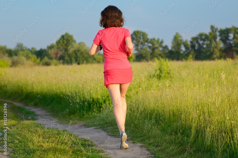 Woman runner jogging on trail outdoors, spring running and exercising
Woman runner jogging on trail outdoors, spring running and exercising