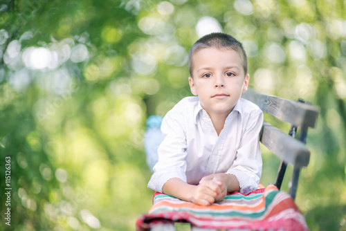 little boy resting on a park bench