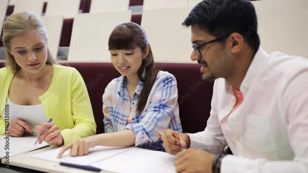 group of students with notebooks in lecture hall group of students with notebooks in lecture hall