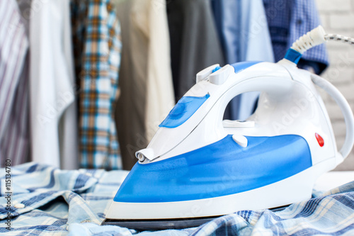 Electric iron and shirt, on cloth background