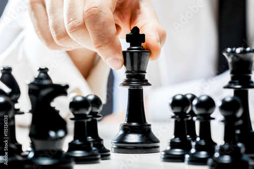 Hand of businessman playing chess