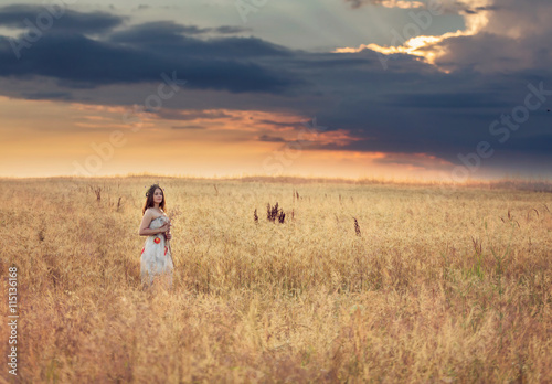Portrait of a young woman in a wheat field  at sunset
