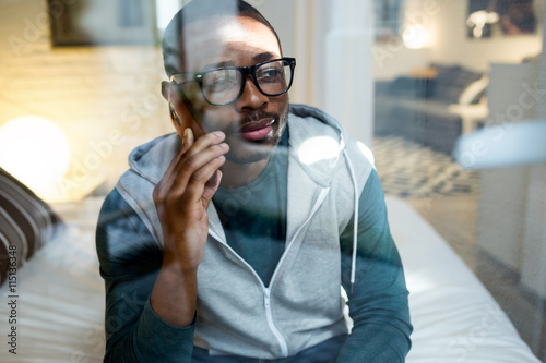 Wallpaper Mural Handsome young black man using his mobile phone at home. Torontodigital.ca