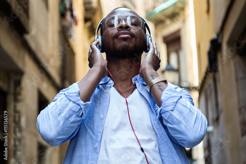 Konstfotografi Handsome young man listening to music with digital tablet.