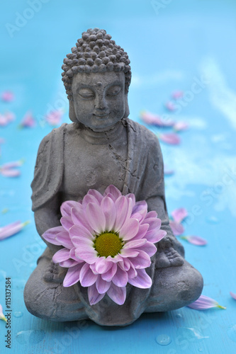 Steinerne Buddha Figur mit Blume photo