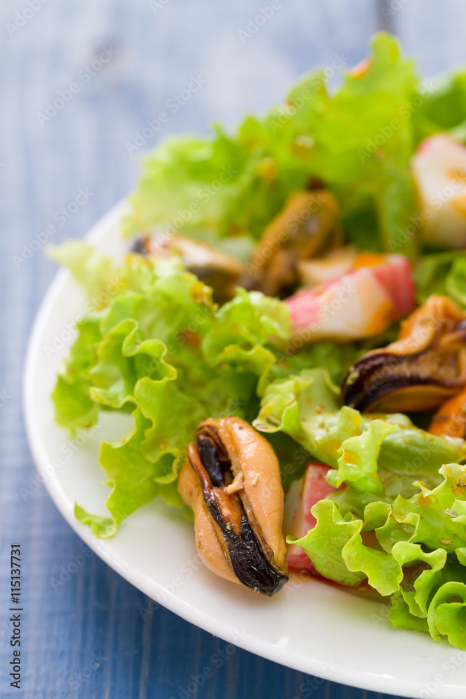 seafood salad on white dish on blue wooden background seafood salad on white dish on blue wooden background