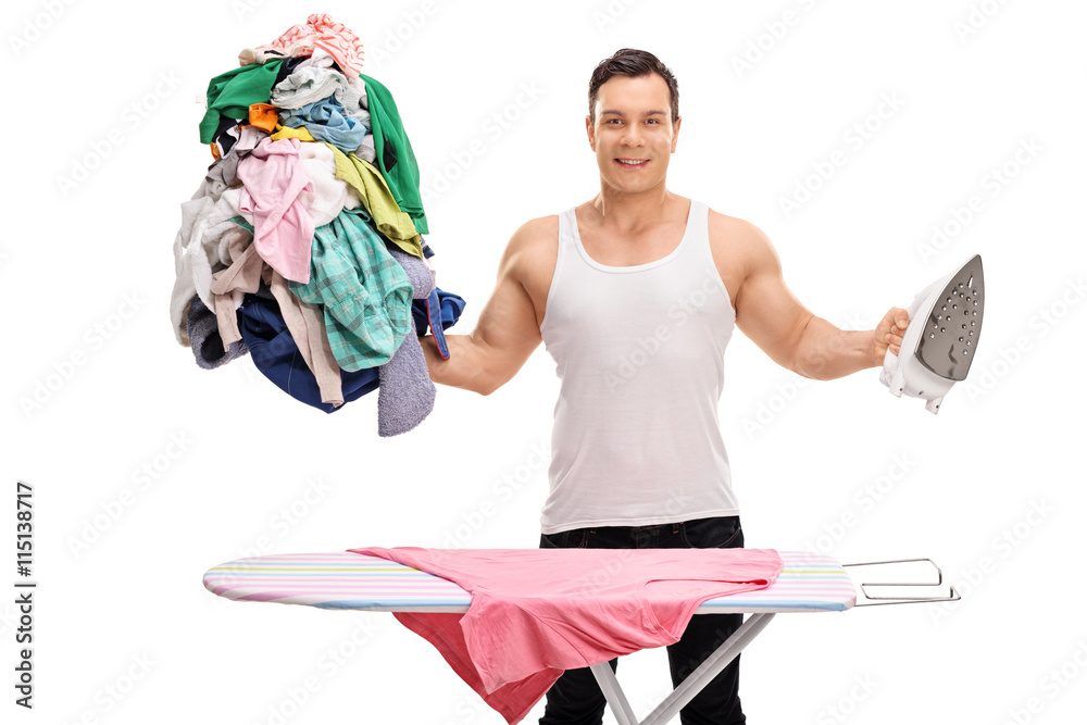 Joyful man ironing a lot of clothes Joyful man ironing a lot of clothes