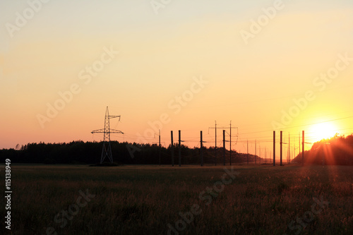 electric and solar energy in the natural landscape/ power line running over the horizon at sunset in the summer 