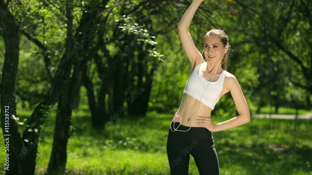 Young woman doing exercises in the park. Pretty girl engaged in fitness outdoors. Cute girl with slim body. Beautiful girl playing sports outdoors. Young woman doing exercises in the park. Pretty girl engaged in fitness outdoors. Cute girl with slim body. Beautiful girl playing sports outdoors.