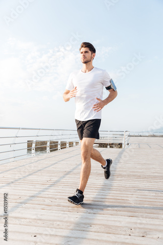 Man athlete running on wooden terrace