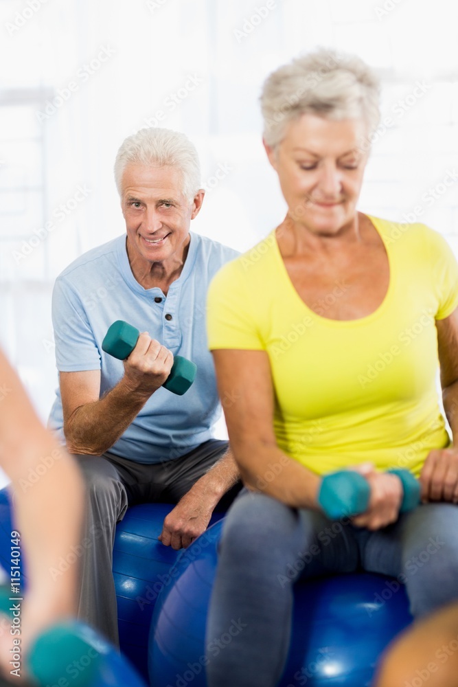 Seniors using exercise ball and weights Seniors using exercise ball and weights