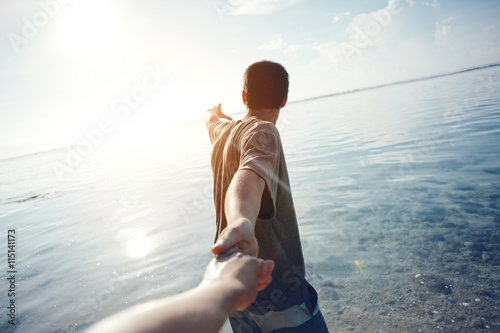 Obraz na płótnie Brave man guiding traveling woman through the water
