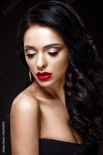 Beautiful woman portrait isolated on black background. Young lady posing with elegant hairstyle, gorgeous make up and red lips.