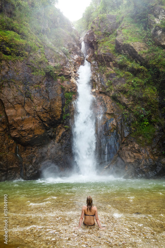 the girl sit in front of waterfall