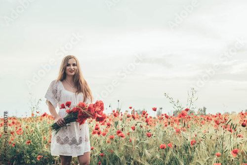 young caucasian female in poppy field enjoying the sunset