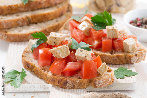 toasts with tomatoes and marinated feta, closeup