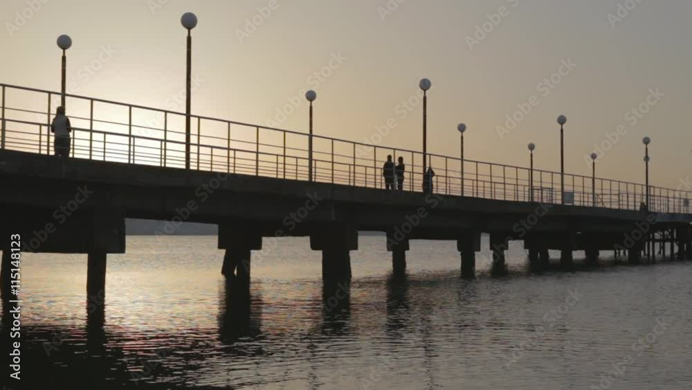 Shooting with drone at sunset in a bay. The drone passes under a pier. N. Shooting with drone at sunset in a bay. The drone passes under a pier. N.