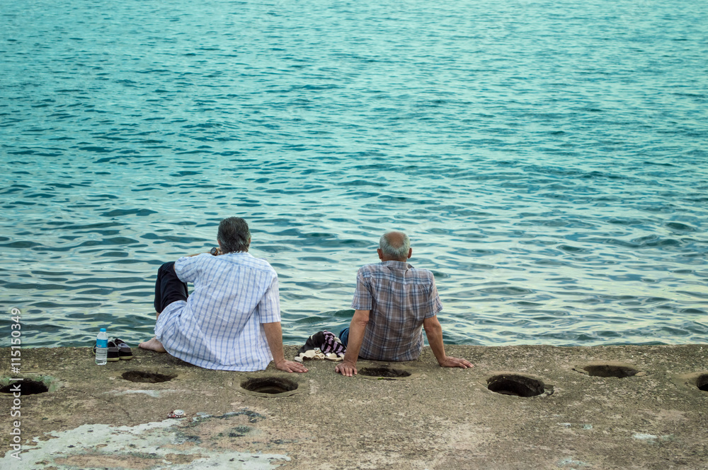 Fototapeta premium Two Men Sitting by the Sea