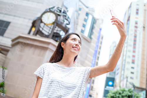 Woman taking selfie in causeway bay of Hong Kong city photo