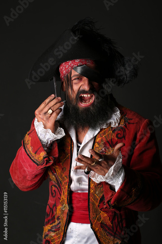 Portrait of man in a pirate costume with mobile phone