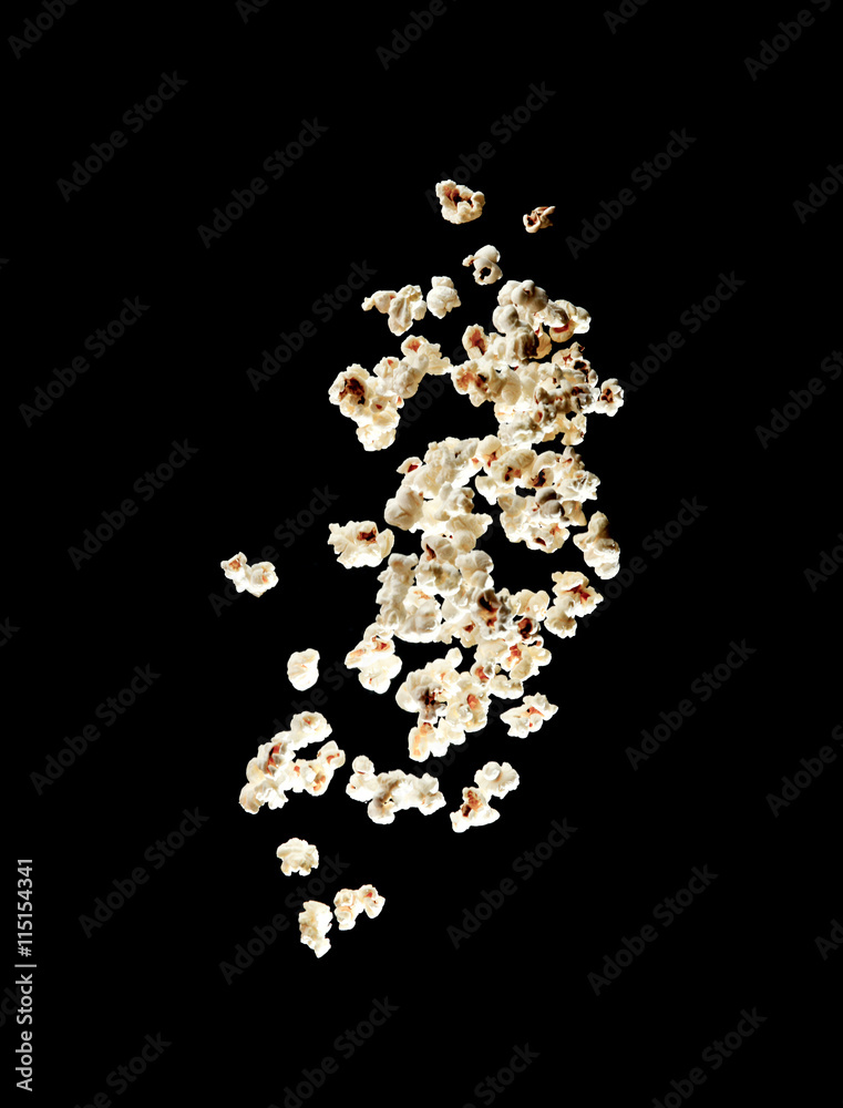 popcorn bursting in the air over black background popcorn bursting in the air over black background