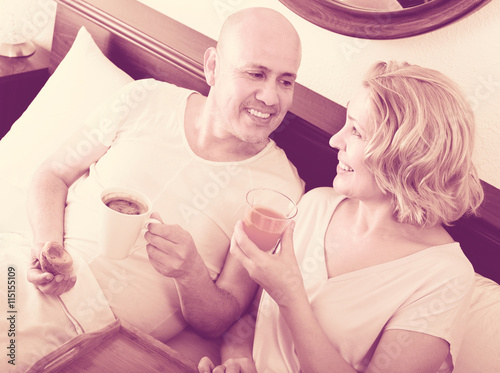 Mature couple having breakfast in bed. photo