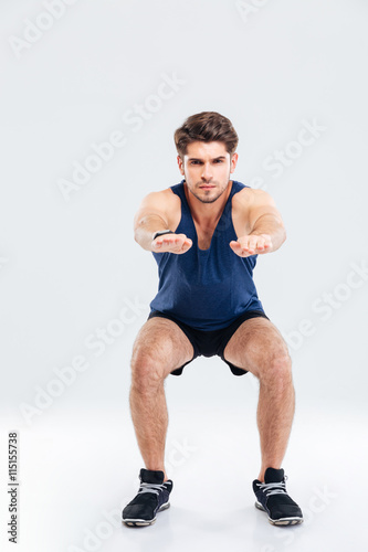 Handsome young sportsman doing squats © Drobot Dean