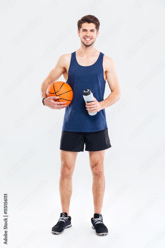 Fotografie Usmíval se mladý sportovec drží míč košem a láhev s vodou
