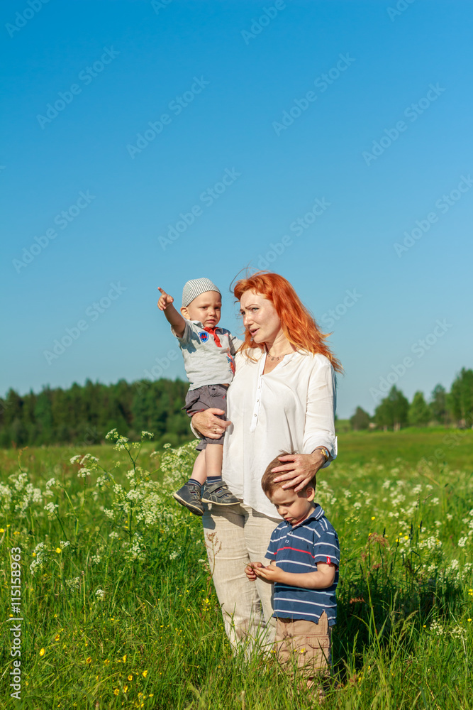 Beautiful red-haired mother playing with children in the field. Beautiful red-haired mother playing with children in the field.