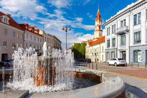 Fountain and church in the old city summer sunny day, Vilnius, Lithuania, Baltic states.
