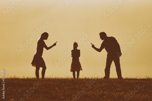 Silhouette of a angry mother and father scolding their daughter.