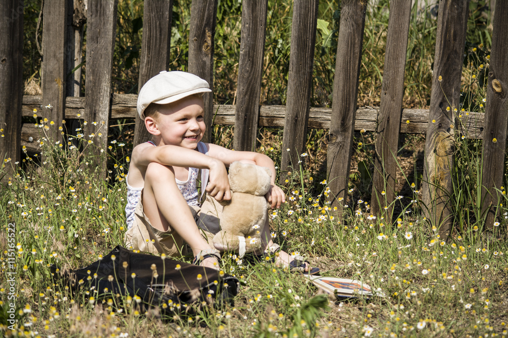 funny little boy sitting on the grass in the village on the nature Stock  Photo | Adobe Stock